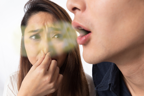 bad breath because of mouth breathing woman pinching her nose
