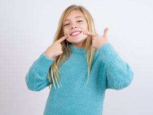 Young girl with a blue shirt and Invisalign braces