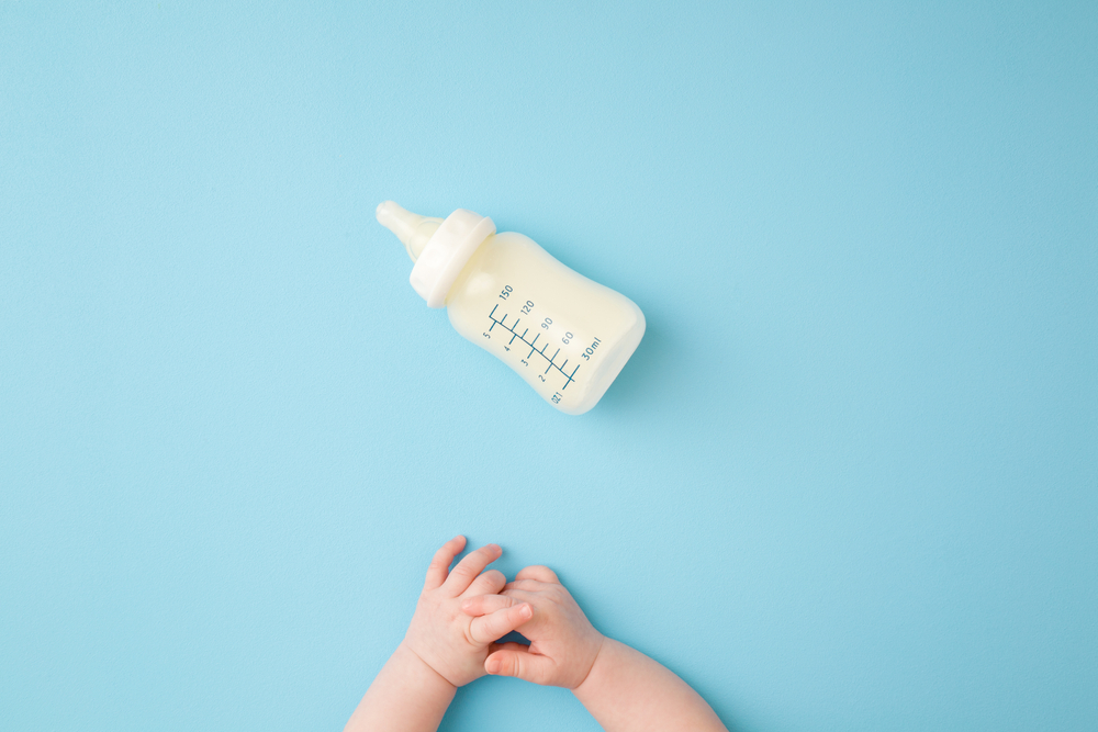 Baby reaching for a bottle.